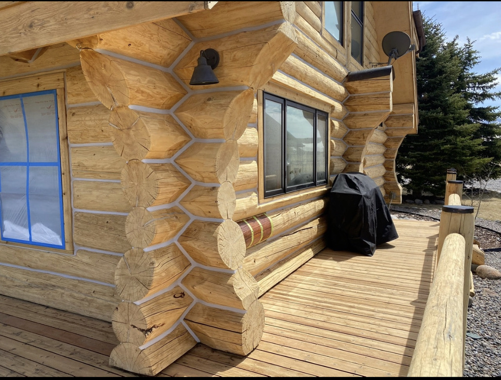 Log home exterior after media blasting with fresh chinking prep
