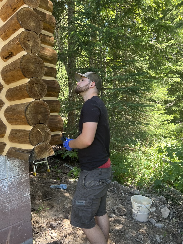 Beaver Creek crew member inspecting log home chinking