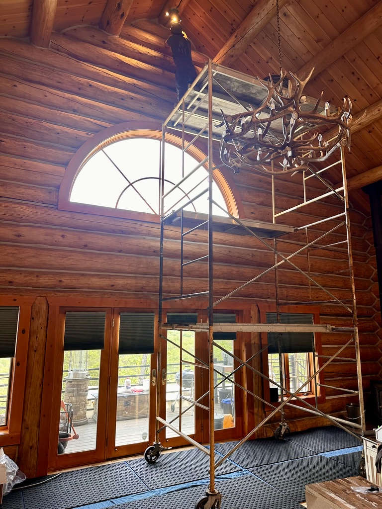 Interior staining with scaffolding in log home great room
