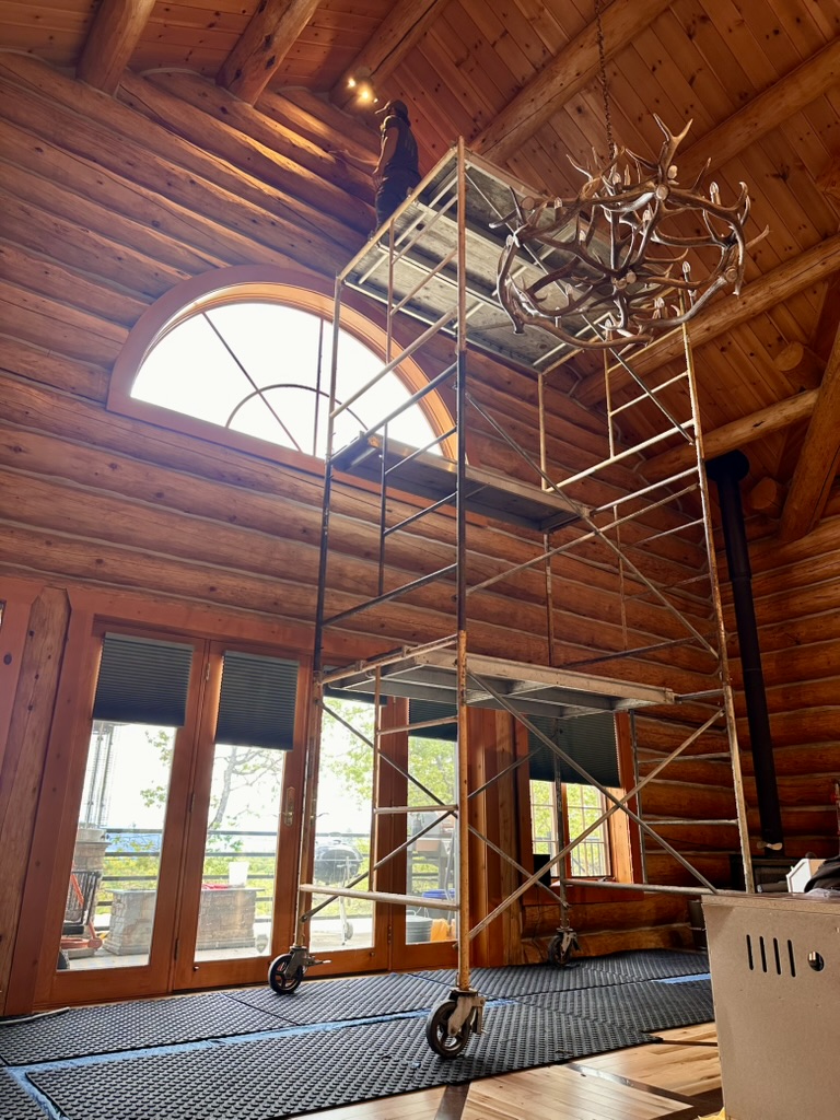 Scaffolding near arched window inside log home