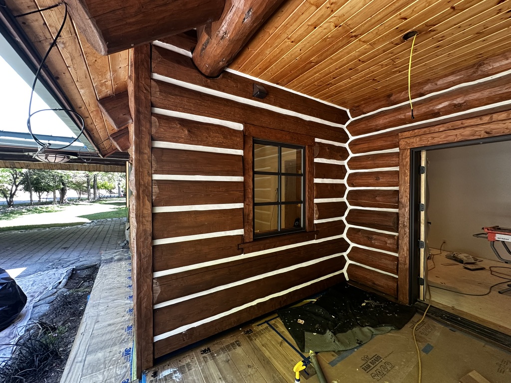 Freshly stained and chinked log home porch area