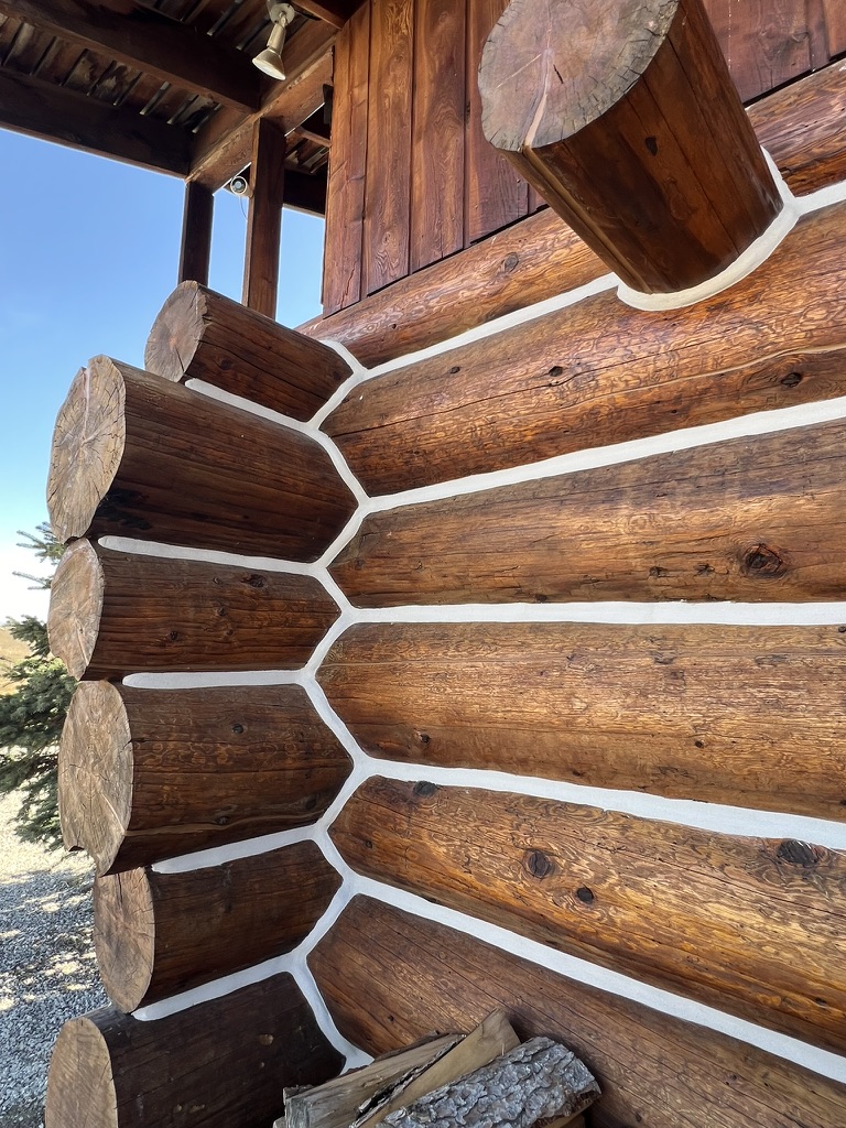 Log home corner showing completed stain and chinking work